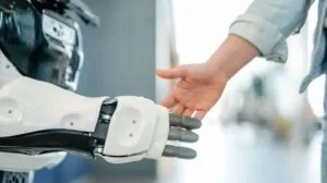 A human hand shaking hands with a robot hand