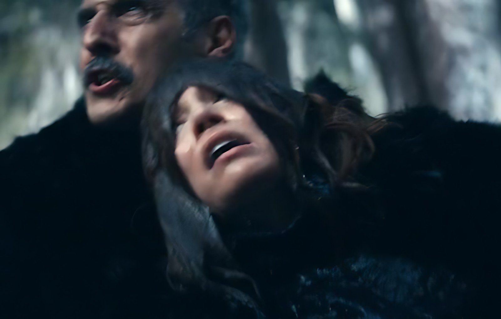 Irv firmly holds Helena as she struggles, desperate to escape the attempted drowning in the snow.