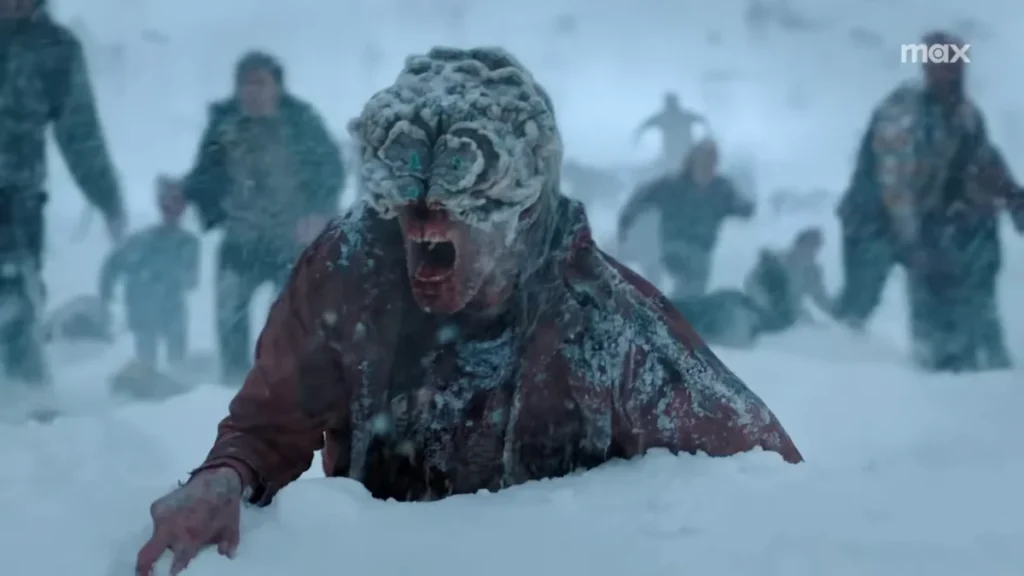 A snow-covered infected crawls on the ground and screams, showing the rising threat in The Last of Us season 2.