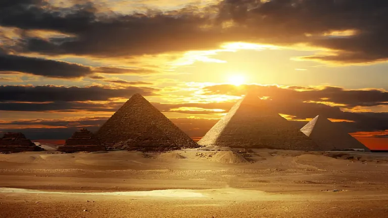 As três grandes pirâmides do Egito iluminadas pelo Sol poente.