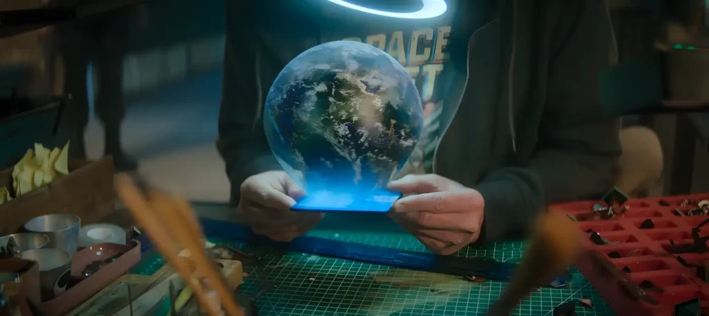 Cena de USS Callister Infinity mostrando o clone de Daly criando mundos digitais em sua oficina.