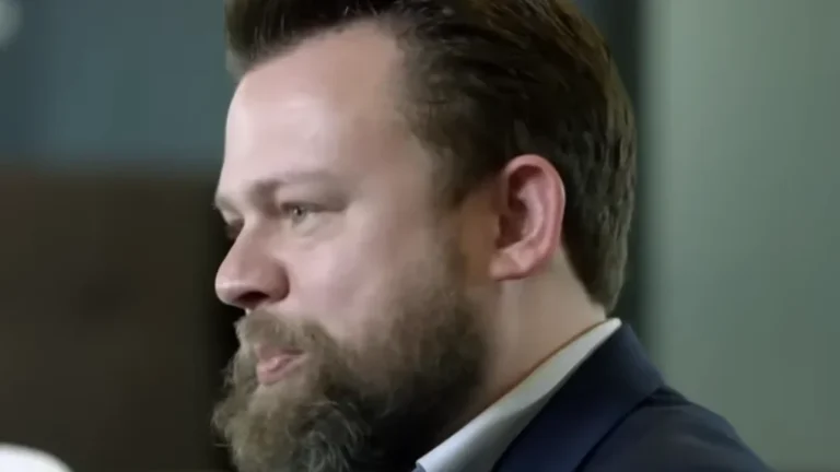 Dan Erickson talks about the cast and behind-the-scenes of Severance, with Britt Lower in the background during the interview.