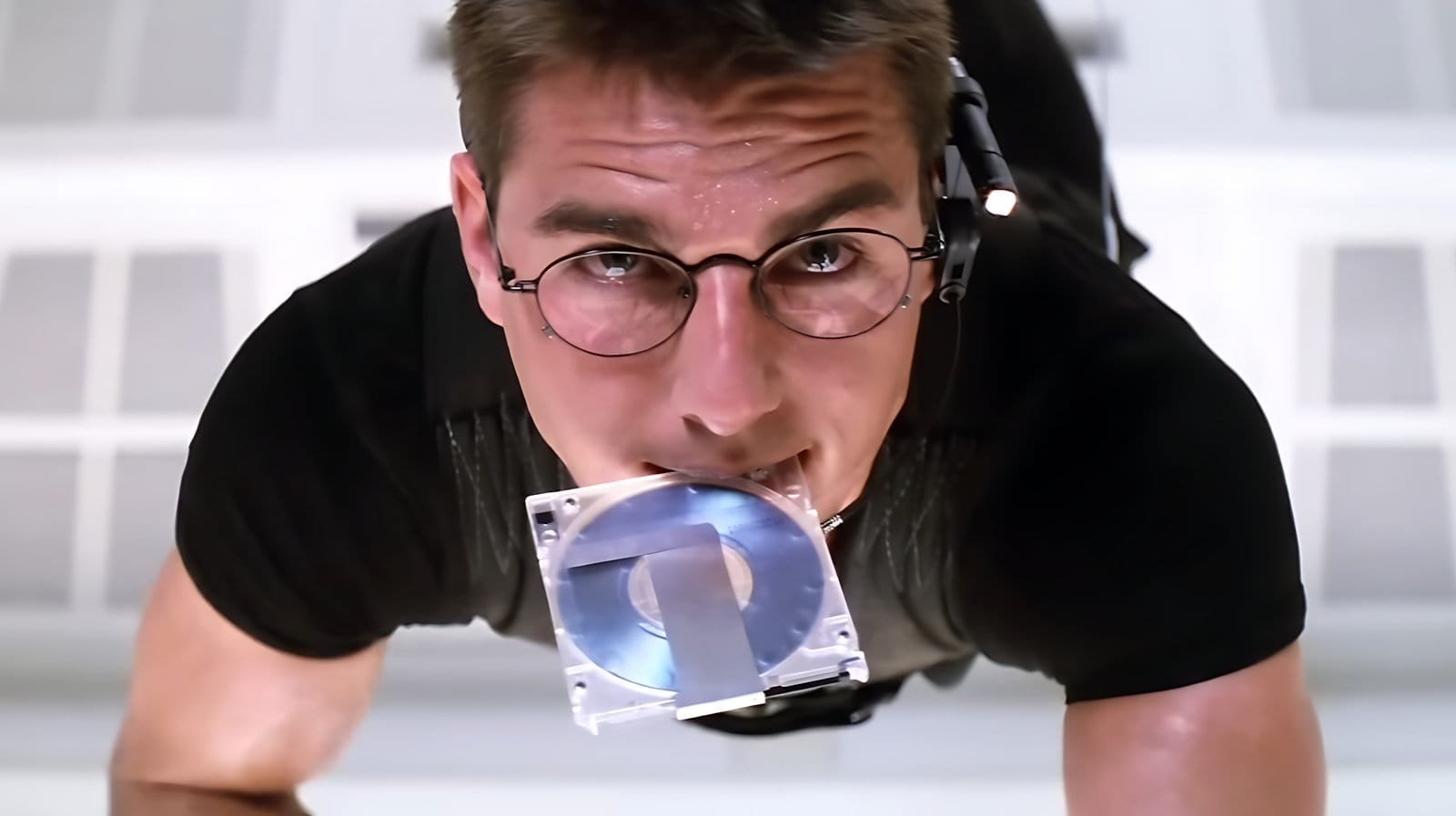 Iconic scene of Ethan Hunt suspended by cables inside the CIA's white vault in Mission: Impossible (1996), played by Tom Cruise.