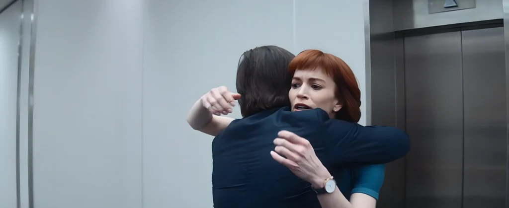 Mark abraça Helly emocionado após sua chegada repentina ao setor, marcando o reencontro dos quatro colegas.