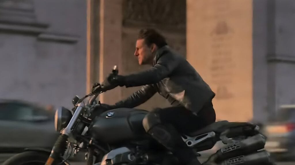 Tom Cruise riding a motorcycle at high speed through the streets of Paris without a helmet in Mission: Impossible – Fallout (2018).