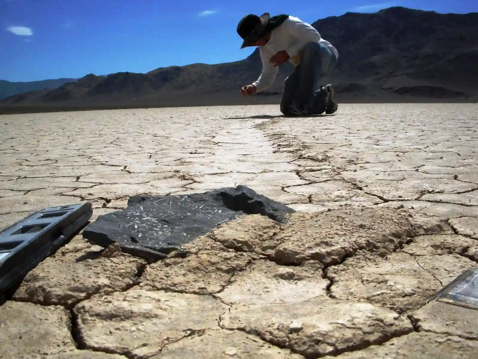 Cover image of Racetrack Playa showing visible trails of rocks that moved across the dry, cracked ground.