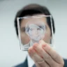 Mark holds and polishes his glass cube with his own face, reflecting on the meaning of the award in the series Severance.