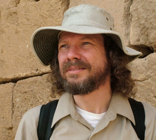 Robert Schoch em campo na Turquia, fotografado por Catherine Ulissey, em meio a formações rochosas e ruínas históricas.