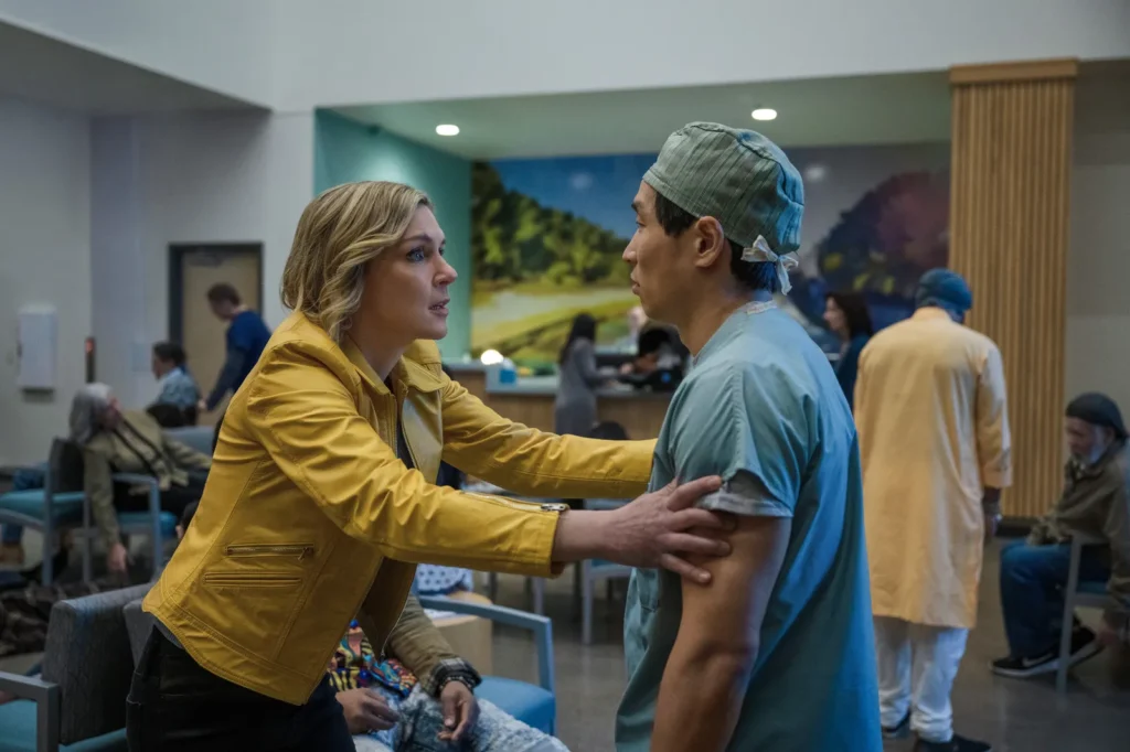 Scene from the series Pluribus where Carol desperately asks an infected nurse for help to save her girlfriend, who is dying, in episode 1 of the first season.