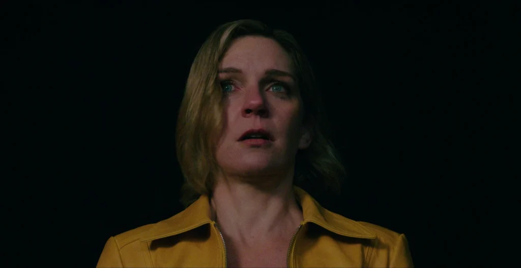 Carol appears frightened shortly after the global infection begins in the series Pluribus, in a scene that marks the initial impact of the virus and the collapse of normal life.