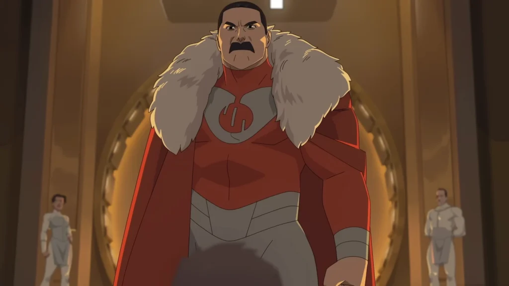 Líder Viltrumita aparece em posição dominante dentro de um salão imponente, vestindo uniforme vermelho com detalhes em pele, representando o poder absoluto e a hierarquia rígida do império Viltrumita em Invencível.